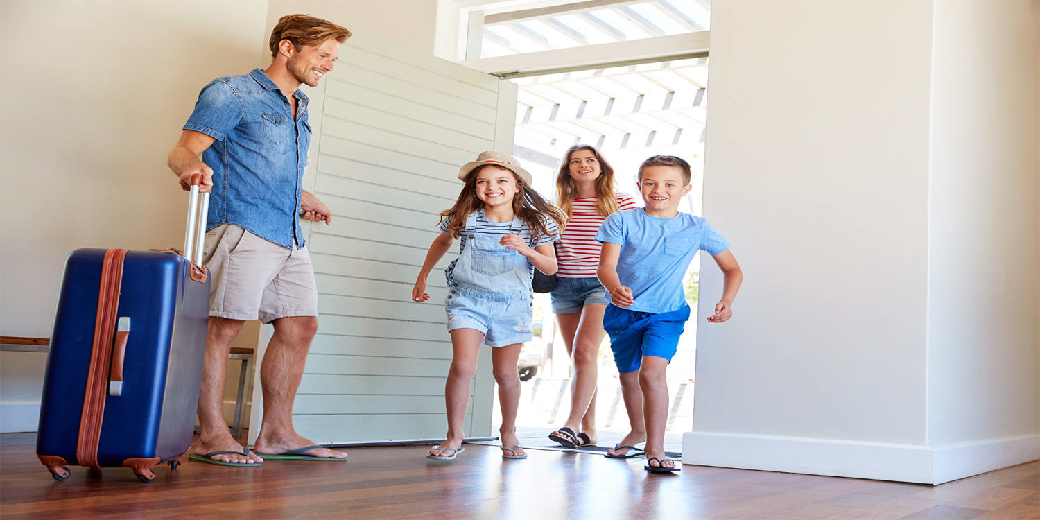 Happy family entering a vacation rental home.